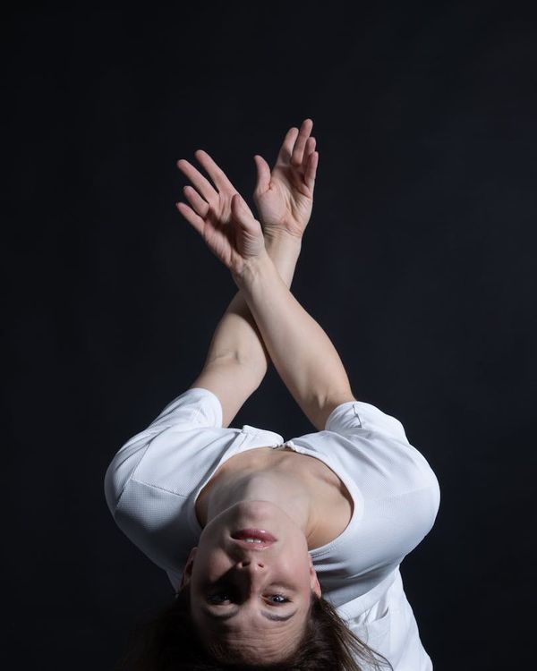 Woman performing a fluid cardio movement in a minimalist studio.